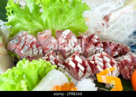 AJI Sashimi, maquereau coupé en tranches frais servi sur une assiette de sashimi mori décorée de laitue verte et de radis déchiquetés. Buffet de cuisine japonaise. Banque D'Images