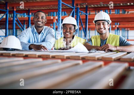 Les bonnes personnes avec les bonnes compétences. Un groupe de constructeurs ayant une réunion dans un chantier. Banque D'Images