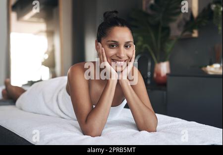 De loin, c'est le meilleur spa. Portrait d'une jeune femme se relaxant sur un lit de massage dans un spa. Banque D'Images