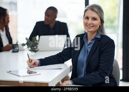 Un excellent plan pour aider vraiment à stimuler la croissance. Une femme d'affaires mûre écrivant des notes pendant une réunion dans un bureau moderne. Banque D'Images