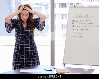 J'ai l'impression que ma tête va exploser. Une jeune femme d'affaires en détresse dans son bureau. Banque D'Images