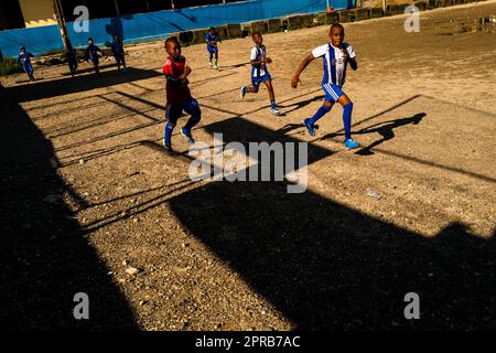 Les garçons afro-colombiens pratiquent des sprints courts lors d'une séance d'entraînement de football sur un terrain de jeu de terre à Quibdó, Chocó, Colombie. Banque D'Images