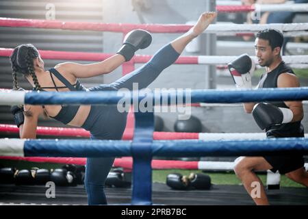 Une équipe de boxe en forme, active et saine qui donne un coup de pied ou s'entraîne dans un centre de bien-être, dans une séance d'entraînement, de musculation ou d'exercice. Kickboxing sportif, sportif ou fort pour hommes et femmes dans les combats ou les matchs sportifs Banque D'Images