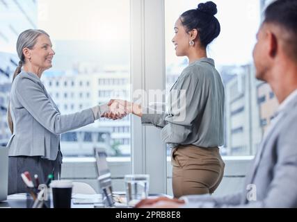 Un succès croissant au jour le jour avec les bonnes personnes. Deux femmes d'affaires se branlant la main pendant une réunion dans un bureau. Banque D'Images