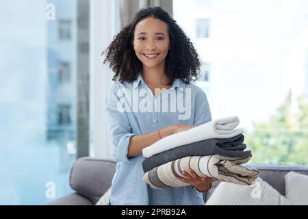 Mon placard de vêtements est sur le point de paraître si agréable. Une jeune femme tenant une pile de linge propre plié. Banque D'Images