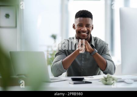 Il est essentiel de se réveiller au quotidien, un jeune homme d'affaires travaillant sur un ordinateur dans un bureau. Banque D'Images