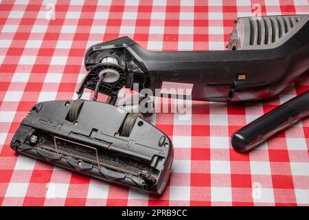 Réparation d'appareils ménagers. Un technicien professionnel répare un aspirateur. Service à la clientèle des appareils ménagers. Batterie hoover. Réparation par un spécialiste sur site. Banque D'Images