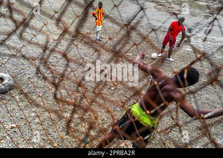 Un jeune joueur de football afro-colombien pratique le tir lors d'une session d'entraînement sur un terrain de jeu de terre à Quibdó, Chocó, Colombie. Banque D'Images