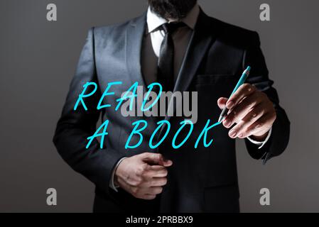 Panneau de texte indiquant Lire Un livre. Idée d'affaires Profitez de la littérature activité traditionnelle apprendre de nouvelles choses homme d'affaires holding Pen et présentant des informations importantes. Banque D'Images