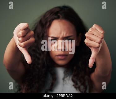 Cela me dévient. Photo studio d'une jeune femme montrant ainsi vers le bas sur un fond vert. Banque D'Images