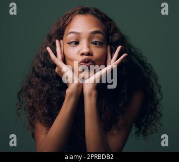 Baiser moi fou. Portrait court d'une jeune femme attrayante et originale se posant sur un fond vert en studio. Banque D'Images