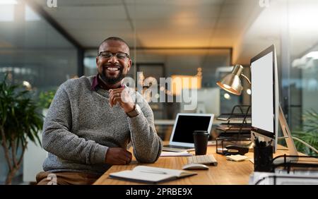 Affichez vos objectifs de jour comme de nuit. Portrait court d'un beau homme d'affaires mature assis seul à son bureau pendant un quart de travail tardif au bureau. Banque D'Images