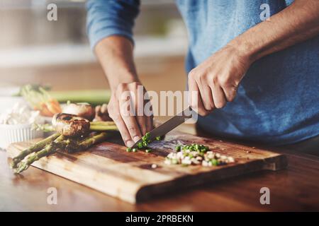 Gros plan de l'homme cuisant dans la cuisine, préparant des aliments avec des légumes frais. Déjeuner fait maison par apprentissage végétarien pour équilibrer la nutrition pour un mode de vie sain. Nutritionniste faire bio repas sans gluten Banque D'Images