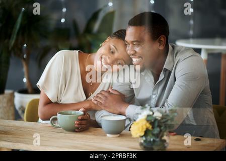 J'adore aussi chaud qu'une tasse fraîche. Un jeune couple passe du temps ensemble dans un café. Banque D'Images