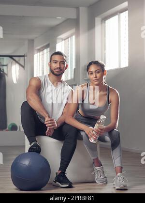 On a eu 99 problèmes et la paresse aint un. Deux jeunes athlètes assis ensemble à la salle de gym. Banque D'Images