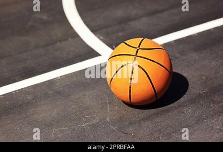 Photographiez. Photo d'un ballon de basket-ball sur le terrain dans un terrain de sport. Banque D'Images