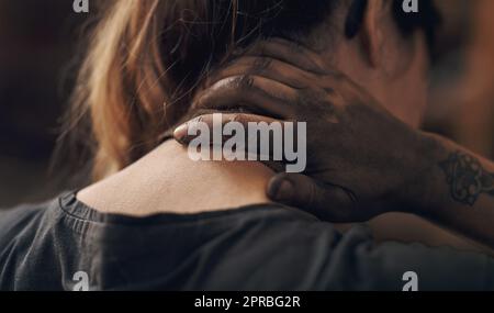 Un effort excessif a un coût. Une jeune femme souffrant de douleurs au cou en travaillant dans une fonderie. Banque D'Images