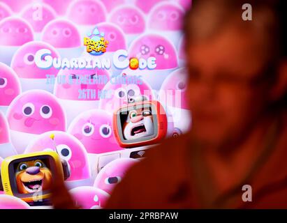 Londres, Grande-Bretagne. 26th avril 2023. Un homme se tient devant une affiche électronique avant la projection dans la presse du film « Guardian Code » à Londres, en Grande-Bretagne, sur 26 avril 2023. Un film familial d'animation chinoise sera projeté sur les écrans de plus de 300 cinémas au Royaume-Uni (Royaume-Uni) et en Irlande sur 26 mai. Le film « Guardian Code », surnommé en anglais, est un épisode de « Boonie Bears », une série de films d'animation largement reconnue par les enfants chinois. Crédit : Li Ying/Xinhua/Alay Live News Banque D'Images
