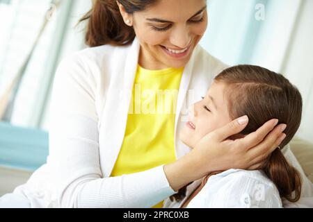 Lui montrant combien elle se soucie. Une mère et une fille étant affectueuses et riant heureux ensemble. Banque D'Images