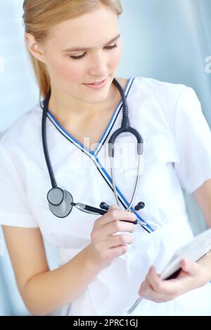 Vérification des fichiers. une infirmière écrit des notes dans son bloc-notes. Banque D'Images