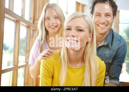 Le plus heureux quand theyre ensemble. Portrait d'une jeune famille heureuse liant à la maison. Banque D'Images