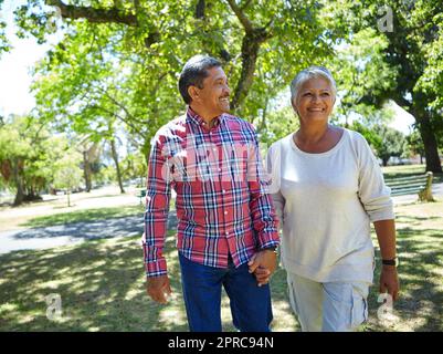 La vie est une promenade dans le parc. un couple de séniors aimant appréciant des vacances de qualité ensemble à l'extérieur. Banque D'Images