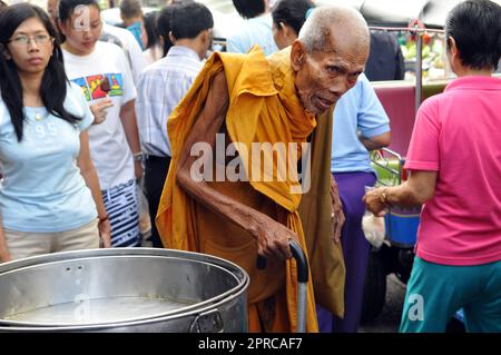 Un très vieux moine bouddhiste marchant dans le marché très animé de Soi Prachum près de Silom Road à Bangkok, en Thaïlande. Banque D'Images