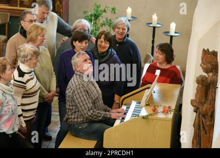 PRODUCTION - 22 avril 2023, Saxe, Bad Düben: Le canteur aveugle de l'église de la ville de Saint Nikolai à Bad Düben, Norbert Britze, chante avec un choeur à un service festif après travaux de rénovation dans l'église de Lindenhayn. Depuis qu'il avait 15 ans, il est clair pour Norbert Britze, aveugle depuis sa naissance, qu'il voulait faire de la musique sa profession. Il a réussi au faire. Depuis 1997, le musicien d'église a travaillé comme canteur et organiste à Bad Düben, conduit plusieurs chorales, y compris l'ensemble vocal ANIMA, fait de la musique dans les garderies et les maisons de retraite, et le suppor Banque D'Images