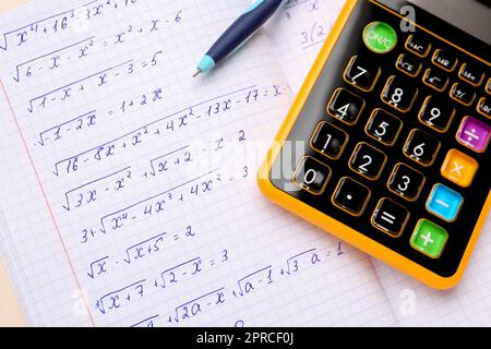 Livre d'or avec formules mathématiques, calculatrice et stylo, gros plan Banque D'Images