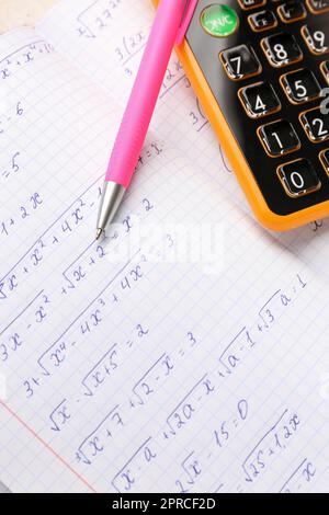 Livre d'or avec formules mathématiques, calculatrice et stylo, gros plan Banque D'Images