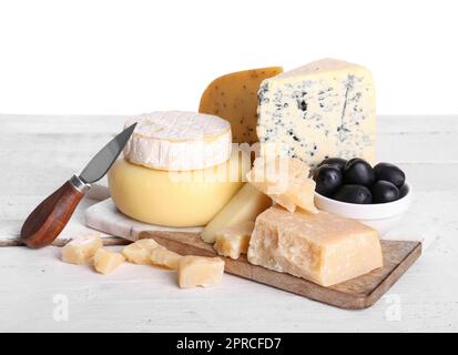 Planche avec différents types de fromage savoureux sur table sur fond blanc Banque D'Images