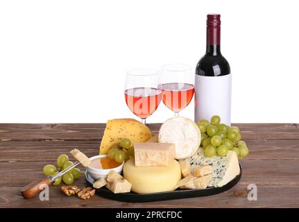 Différents types de fromages savoureux, raisins, bouteille et verres avec vin sur table sur fond blanc Banque D'Images