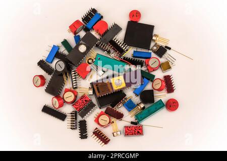 Un groupe d'anciens composants électroniques s'empilent sur fond blanc. Banque D'Images