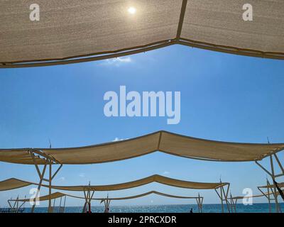 Auvent du soleil parasols sur le fond du ciel bleu sur la plage dans la station touristique tropicale chaude de paradis de pays en vacances Banque D'Images