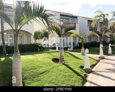 Vue sur le parc et le chemin en pierre et le magnifique bâtiment arabe musulman en pierre blanche, les cottages, les maisons sur fond de verdure tropicale Banque D'Images