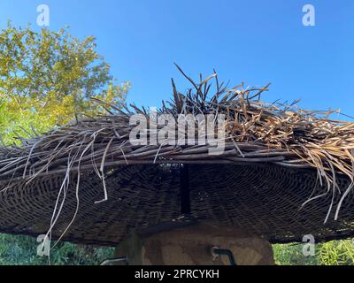 Vue sur le ciel bleu à travers un parasol de plage de paille. Majorque. Espagne. Banque D'Images