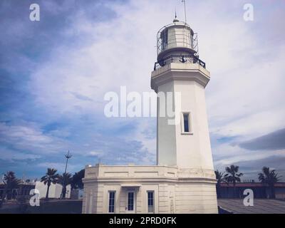 Grand grand phare blanc en pierre sur la mer tropicale chaude station d'été avec des palmiers contre le ciel bleu. Banque D'Images