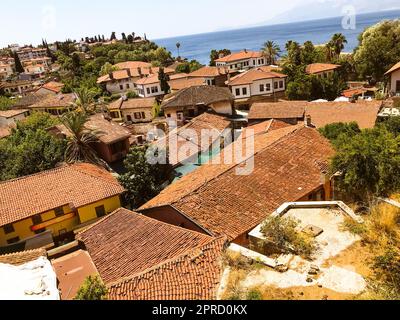 quartier résidentiel dans un pays tropical chaud. de petites maisons avec un toit en tuiles se dressent sur une colline près de la mer. logement pour les habitants pauvres. près des maisons gre Banque D'Images