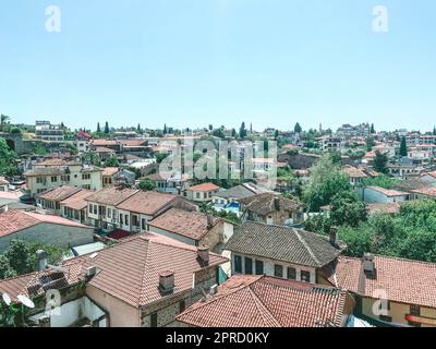 vue d'une hauteur d'un petit village de résidents locaux. petites maisons avec un toit en tuiles sur fond de palmiers et d'arbustes verts. maisons basses Banque D'Images