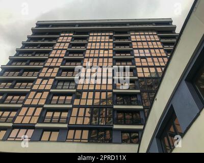 bâtiment résidentiel, haut, avec fenêtres dépolies dans le centre de la ville. un gratte-ciel en verre bleu et blanc avec une transition vers un autre bâtiment. f Banque D'Images