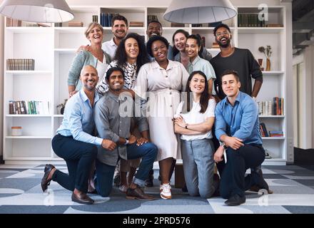 Notre équipe a toujours été la plus dévouée. Portrait d'un groupe diversifié d'hommes d'affaires réunis dans un bureau. Banque D'Images