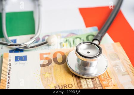 Stéthoscope noir avec billets en euros sur fond de drapeau italien, concept d'affaires et de finances. Banque D'Images