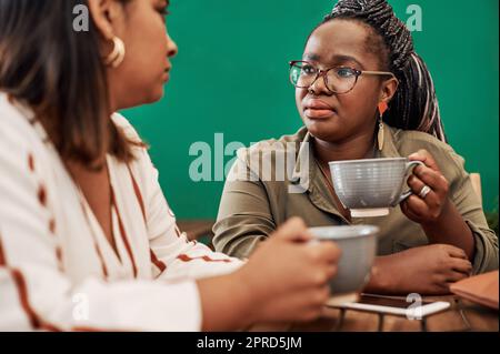 N'oubliez pas de vous enregistrer avec vos amis. Deux jeunes femmes bavardent dans un café. Banque D'Images