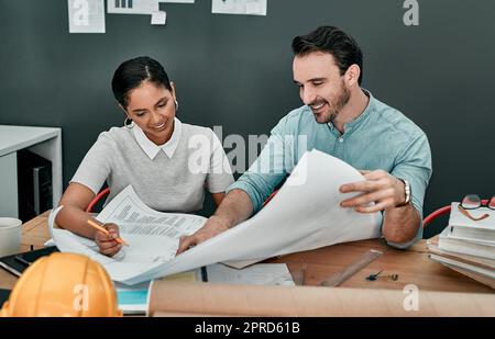 Leurs compétences créatives sont exceptionnelles. Deux architectes travaillant avec des plans dans un bureau. Banque D'Images