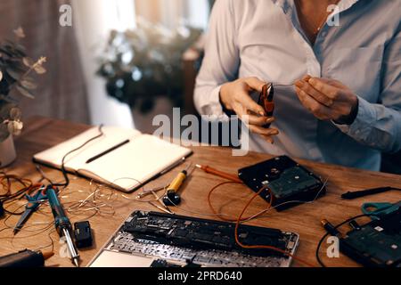 Il est presque prêt à être remis en service. Une femme non reconnaissable qui répare un disque dur dans son atelier. Banque D'Images