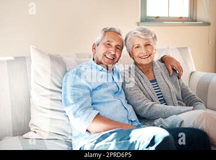 Une fois, il s'est transformé en heureux toujours après. Un couple senior se détendant ensemble sur le canapé à la maison. Banque D'Images