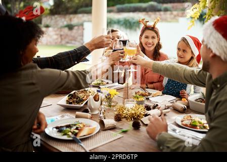 Rien n'apporte de famille comme Noël. Une famille qui fait un toast le jour de Noël. Banque D'Images