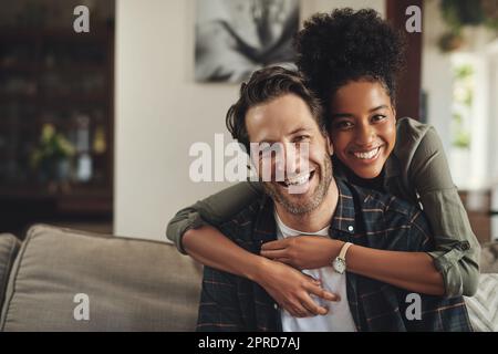 Nous n'apportons rien d'autre que le bonheur dans la vie des autres. Portrait d'un jeune couple affectueux qui passe la journée ensemble à la maison. Banque D'Images