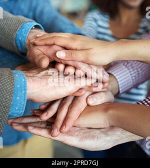 Mains empilées et empilées pour montrer l'unité, la force ou la motivation de l'équipe parmi les hommes d'affaires, les femmes ou les collègues de bureau. Gros plan d'un groupe restreint de gens d'affaires occasionnels montrant du soutien, de la confiance ou du travail d'équipe Banque D'Images