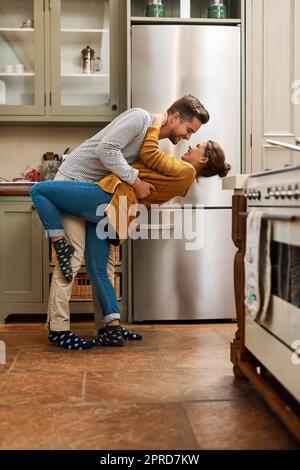 Son temps de Tango dans la cuisine. Photo d'un jeune couple affectueux dansant ensemble dans sa cuisine à venir. Banque D'Images